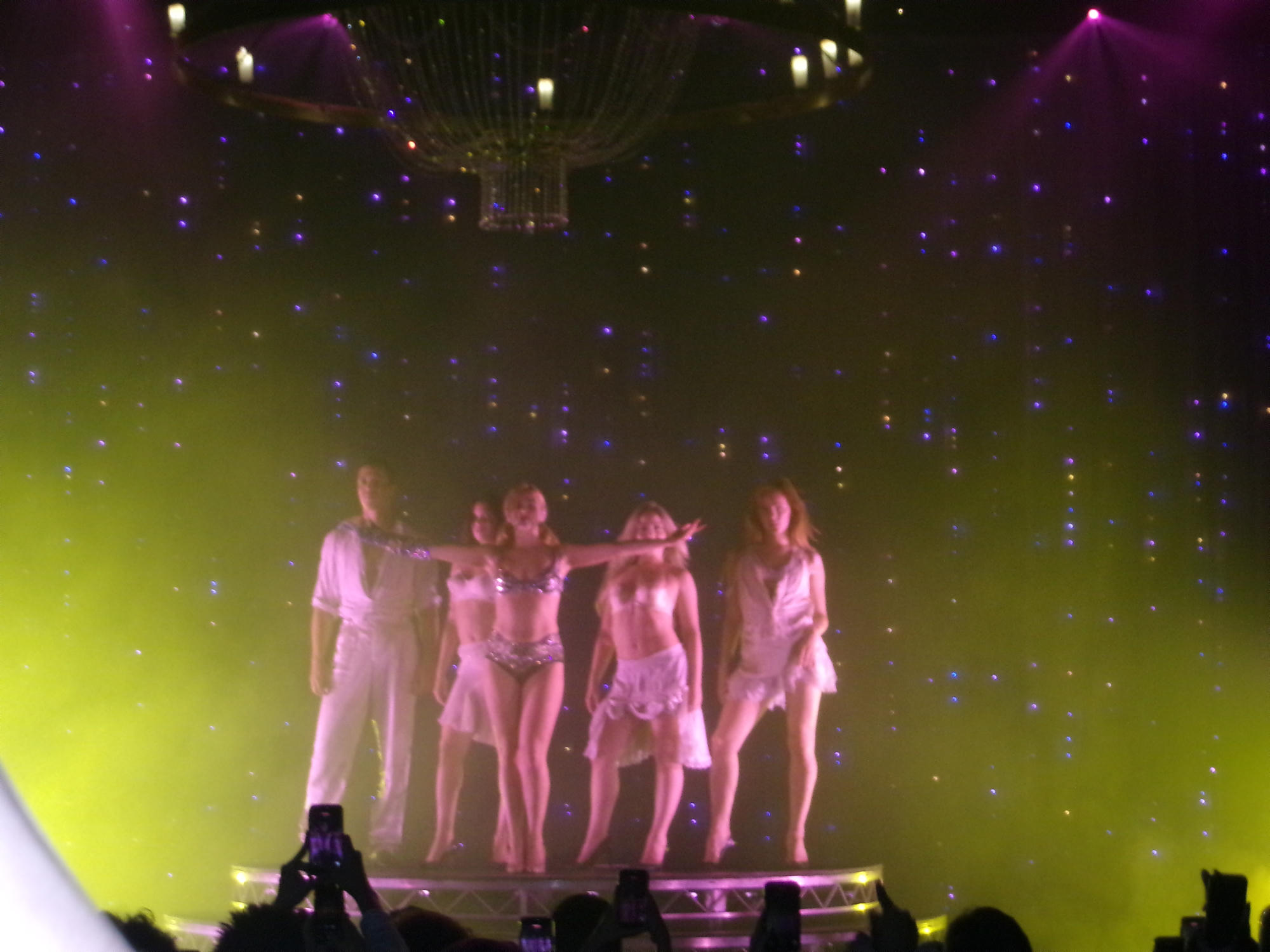 Performers on a brightly lit concert stage.