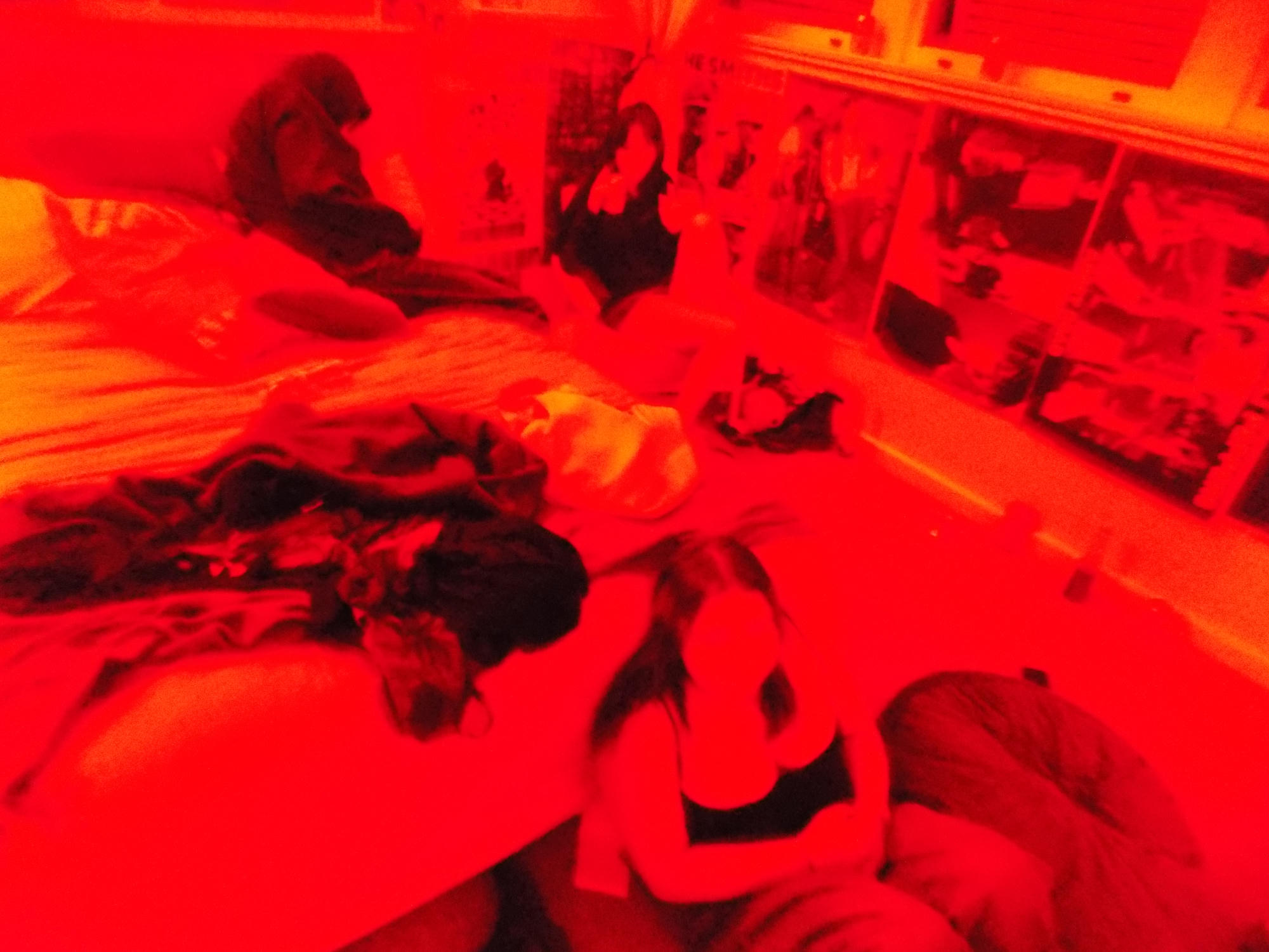 A red-lit room filled with photographs and people.